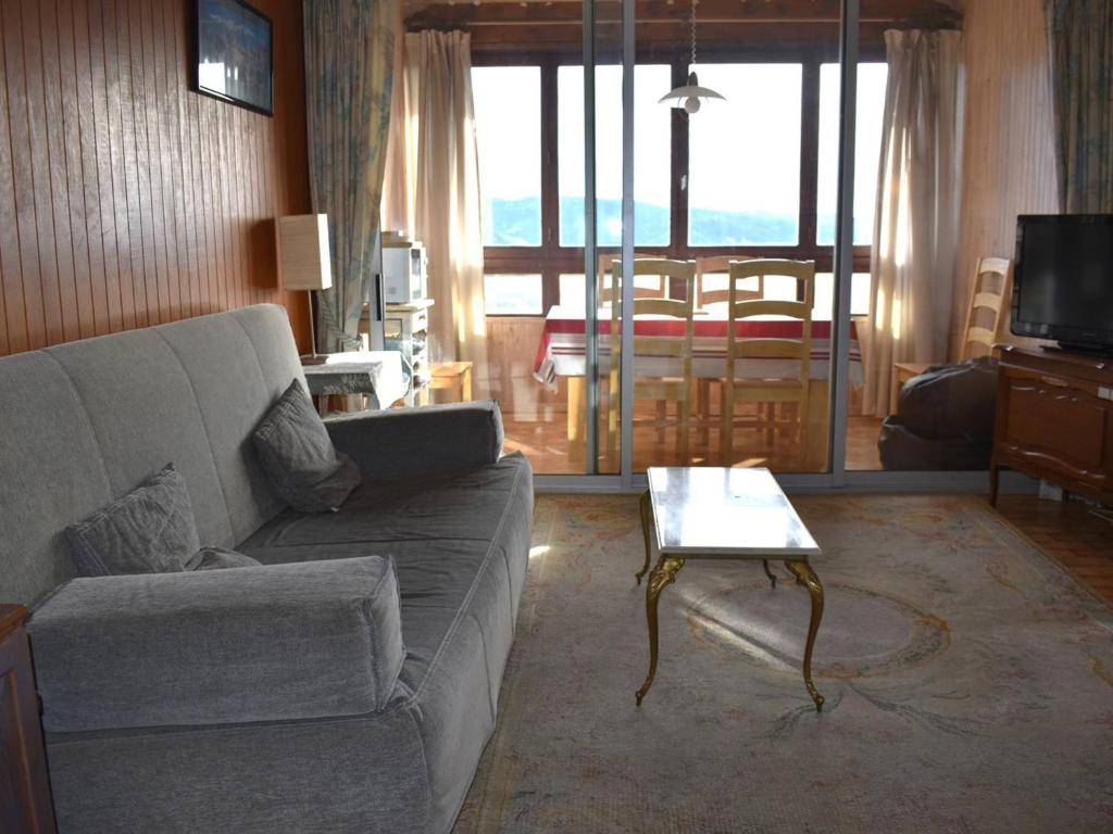 uma sala de estar com um sofá e uma mesa em Appartement Font-Romeu-Odeillo-Via, 2 pièces, 6 personnes - FR-1-580-36 em Font Romeu Odeillo Via
