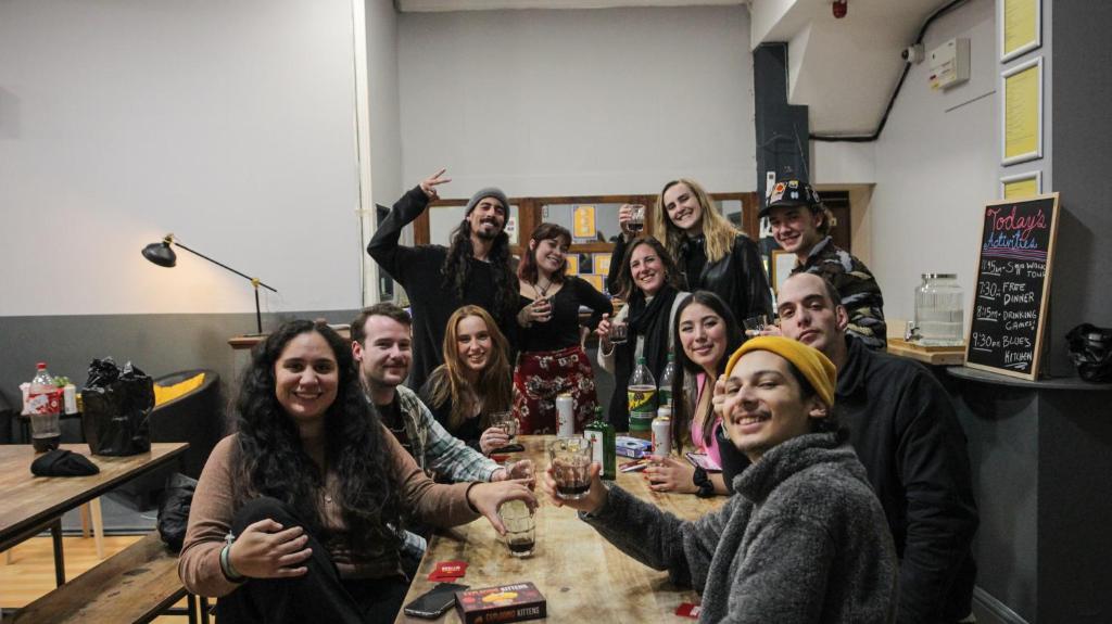 un groupe de personnes assises à une table avec des verres à vin dans l'établissement Onefam Waterloo 18-36 years old, à Londres