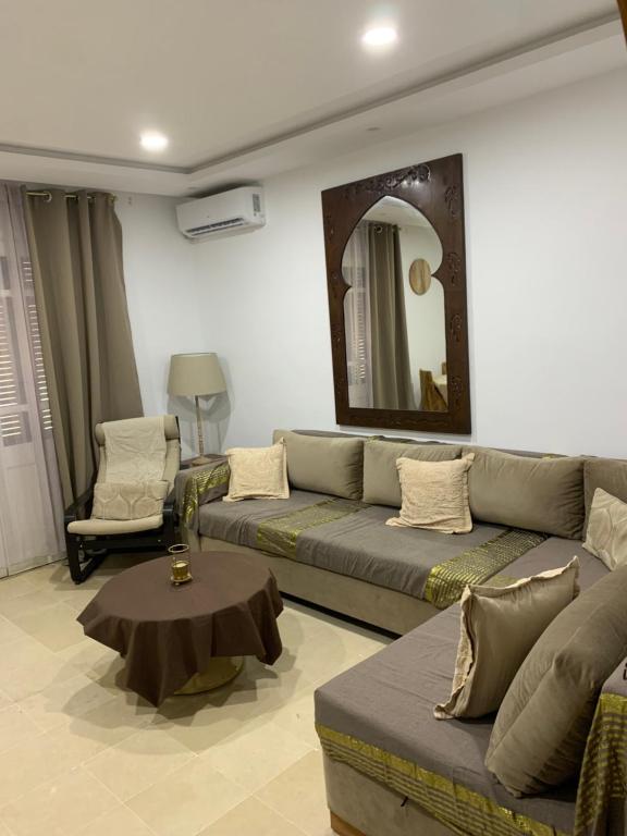 a living room with a couch and a mirror at Appartement - Résidence Port Yasmine Hammamet in Hammamet