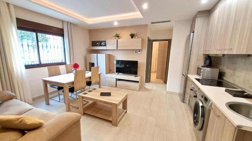 cocina y sala de estar con sofá y mesa en Apartamentos Vacacionales Joctis, Bajo A, en Fuengirola