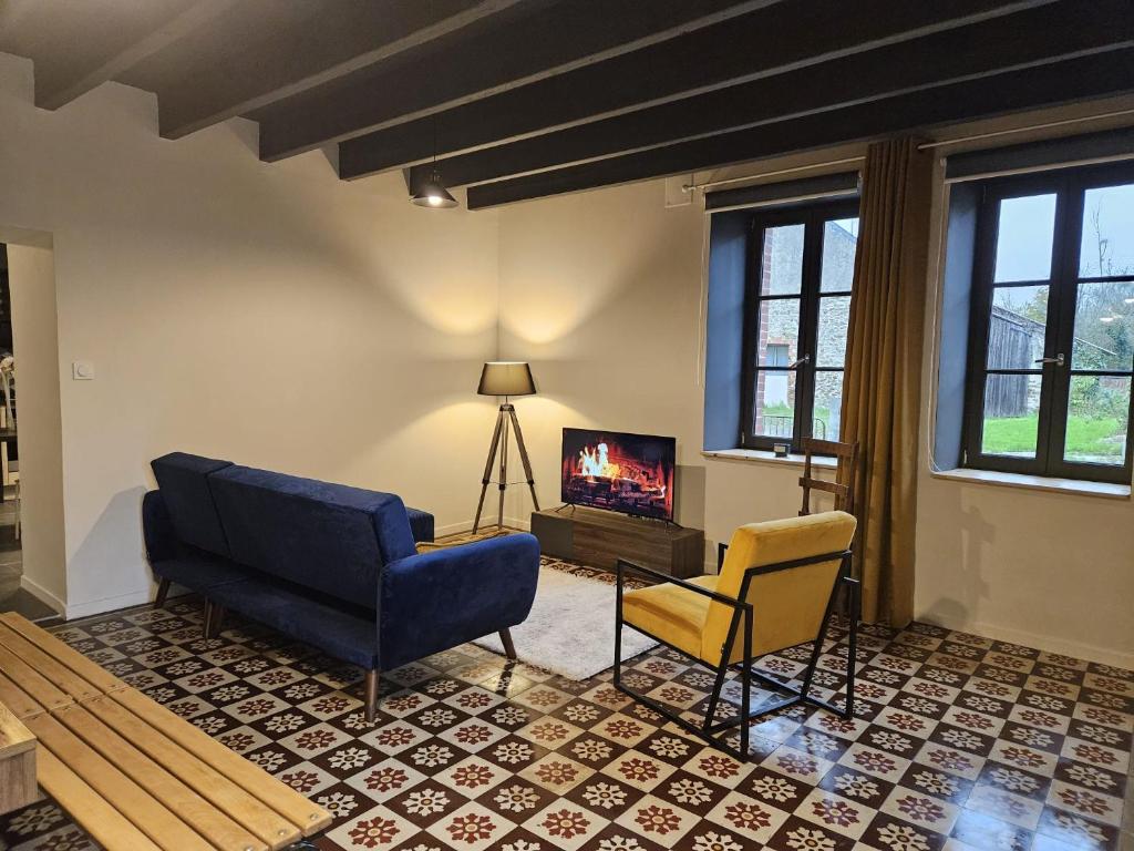 sala de estar con sofá, 2 sillas y TV en Le refuge de Loire, en Montrelais