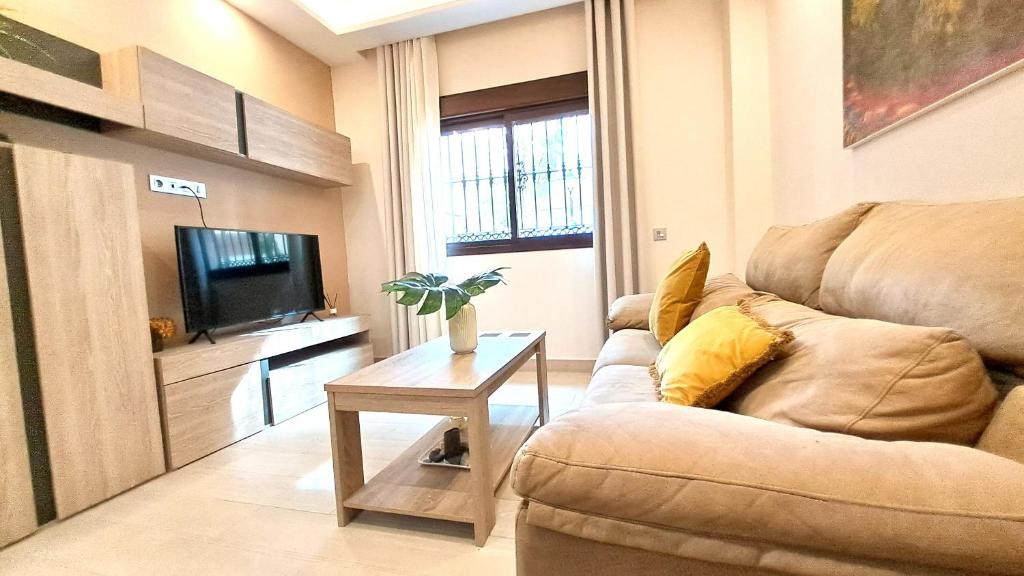 sala de estar con sofá y mesa en Apartamentos Vacacionales Joctis, Bajo B en Fuengirola