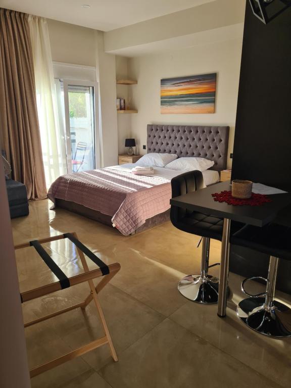 1 dormitorio con cama, escritorio y mesa en Fay's luxury loft, en Volos