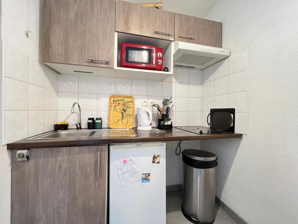 a small kitchen with a microwave and a refrigerator at Mon Cocon Occitan - 2p - Wifi &amp; Parking in Colomiers