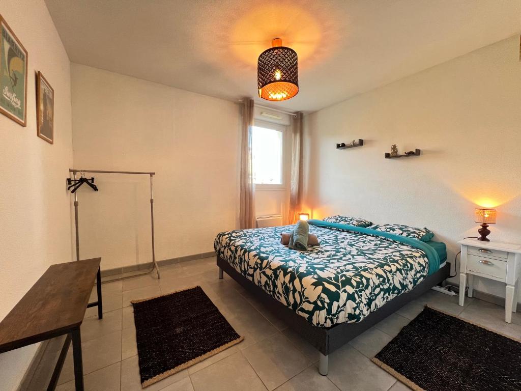 a bedroom with a bed and a table and a window at Mon Cocon Occitan - 2p - Wifi &amp; Parking in Colomiers