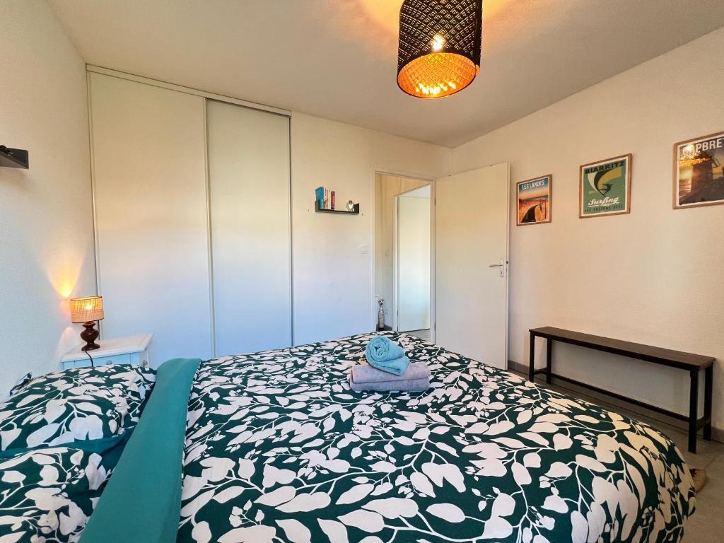 a bedroom with a bed with a green and white comforter at Mon Cocon Occitan - 2p - Wifi &amp; Parking in Colomiers