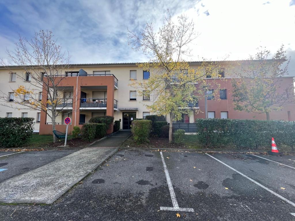 an empty parking lot in front of a building at Mon Cocon Occitan - 2p - Wifi &amp; Parking in Colomiers