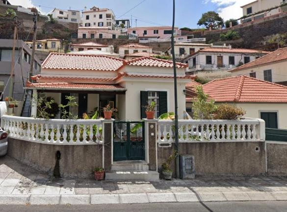 uma casa com um corrimão branco e uma varanda em Tiny House Funchal no Funchal