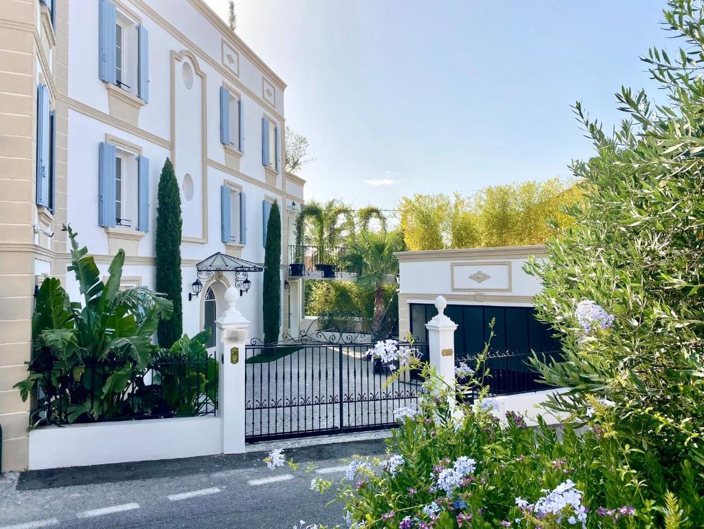 un cancello di fronte a una casa con fiori di Villa Caprice a Six-Fours-les-Plages