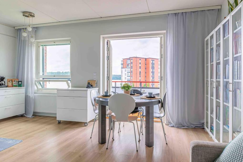 a dining room with a table and chairs and a window at Light modern Pallo apartment by the lake Saimaa in Lappeenranta
