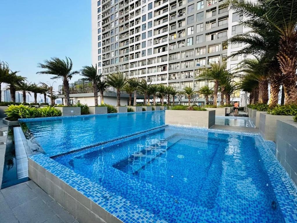 una grande piscina di fronte a un alto edificio di Moon's Home ad Ho Chi Minh