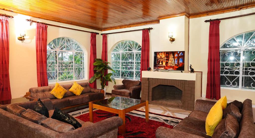 ein Wohnzimmer mit Sofas und einem Kamin in der Unterkunft Naivasha TownHouse in Naivasha