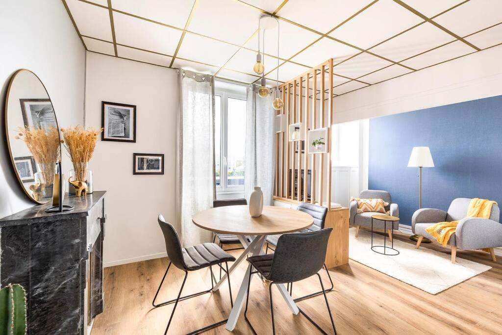 un salon avec une table et des chaises dans l'établissement Appartement cozy en face de la gare - Saint-Brieuc, à Saint-Brieuc