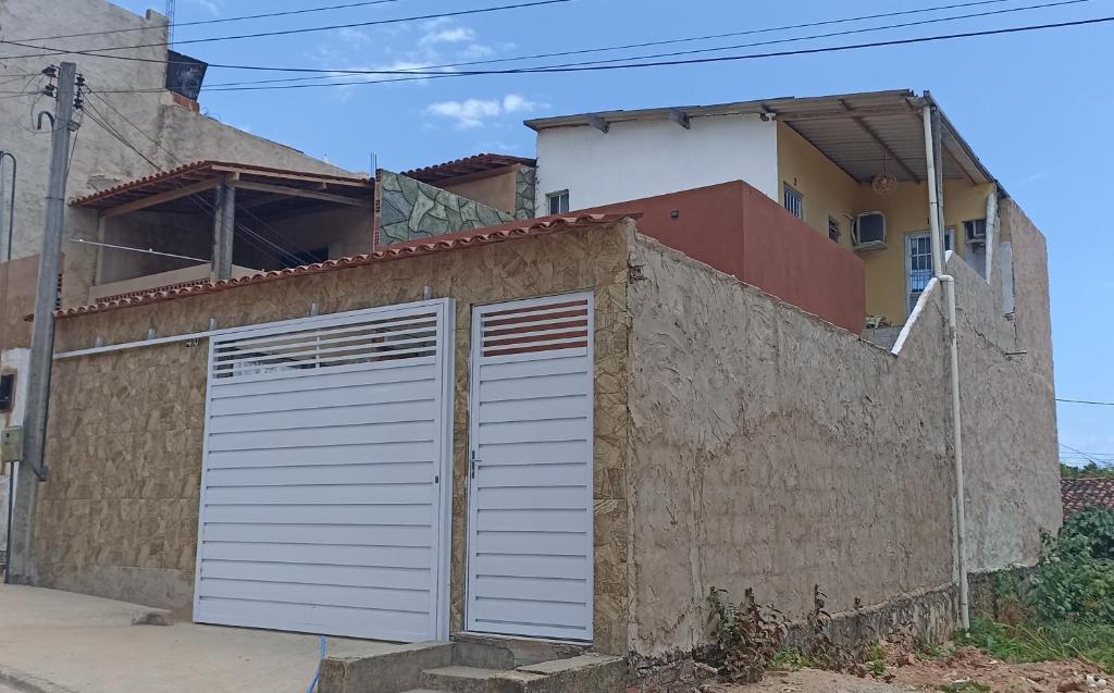 een gebouw met een garagedeur voor een huis bij Hospedagem ensolarada in Japaratinga
