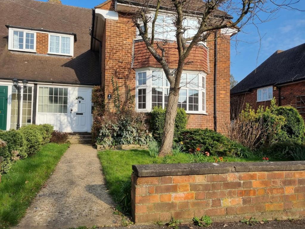 a brick house with a white door at Beautiful 4 bedroom house 7 minutes from Luton Airport in Luton
