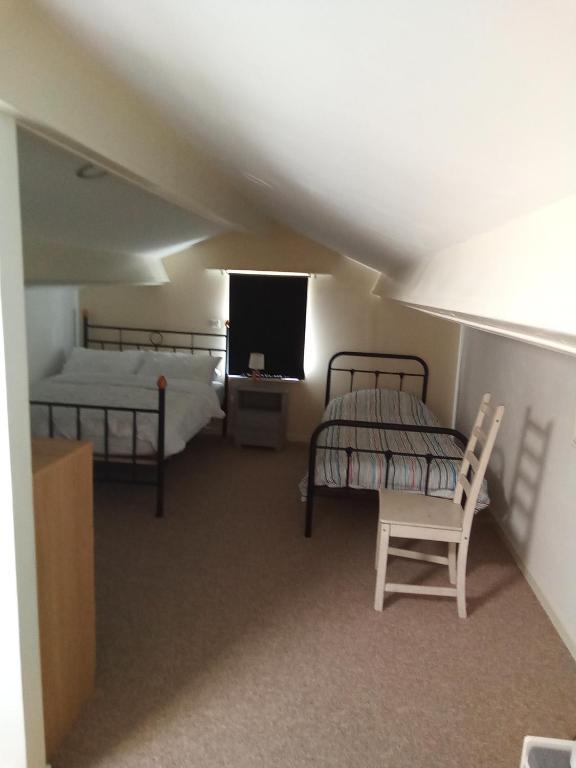 - une chambre avec 2 lits, une télévision et une chaise dans l'établissement Modern one bedroom cottage, à Saint-Mandé-sur-Brédoire