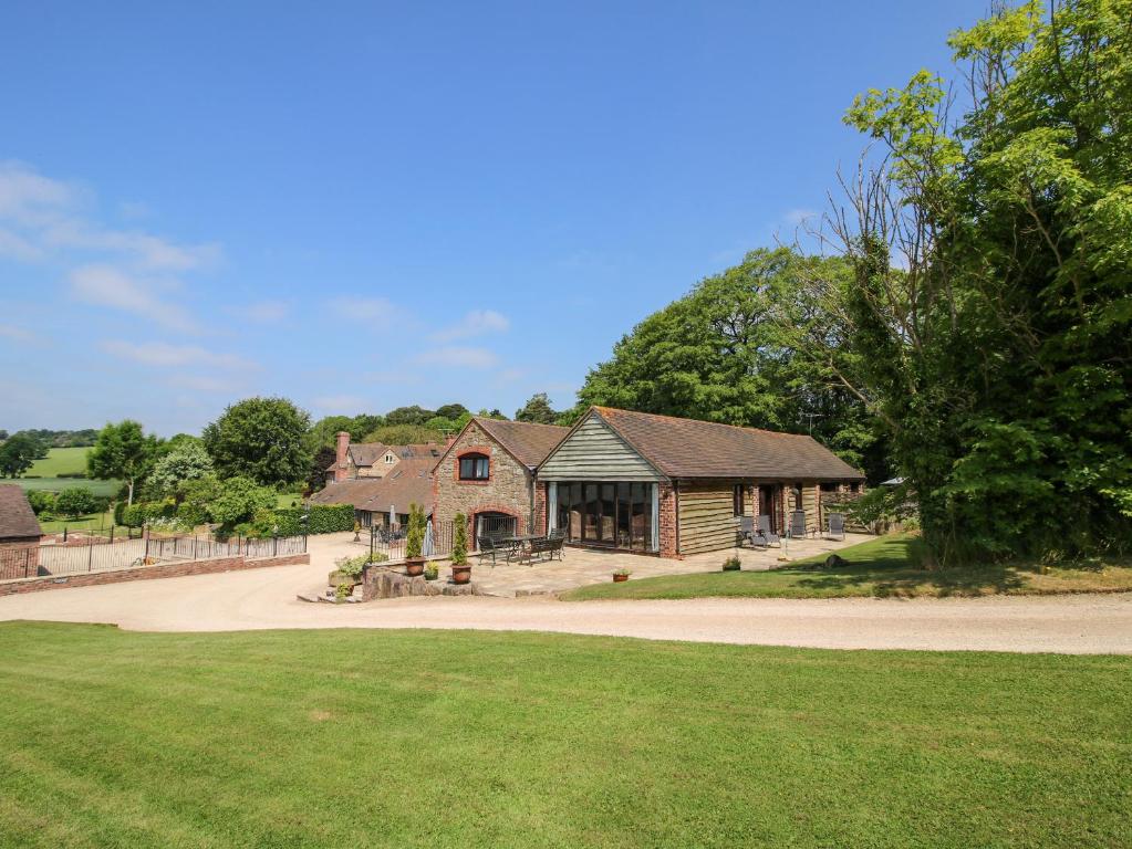 a large house with a driveway and a grass field at Turnip House in Plaish