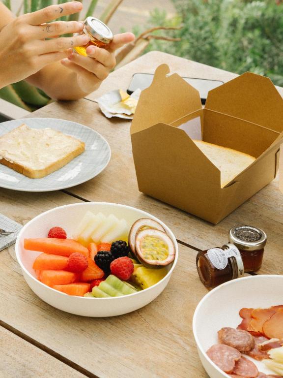 a table topped with plates of food and a box of crackers at 7Pines Resort Ibiza, part of Destination by Hyatt in San Jose