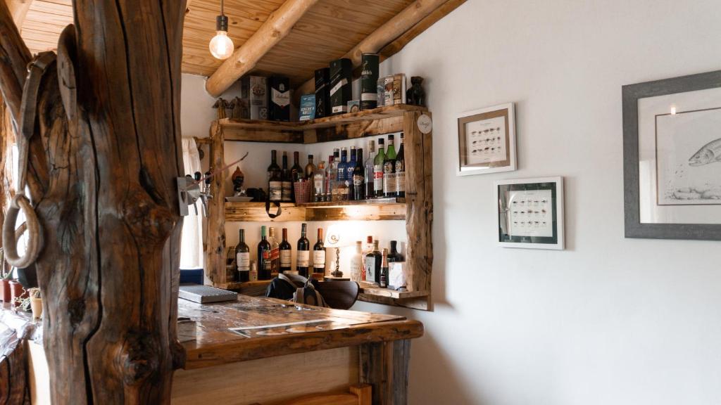 a bar in a room with bottles on the wall at Cabañas El Arriero Lodge in Manzano Amargo