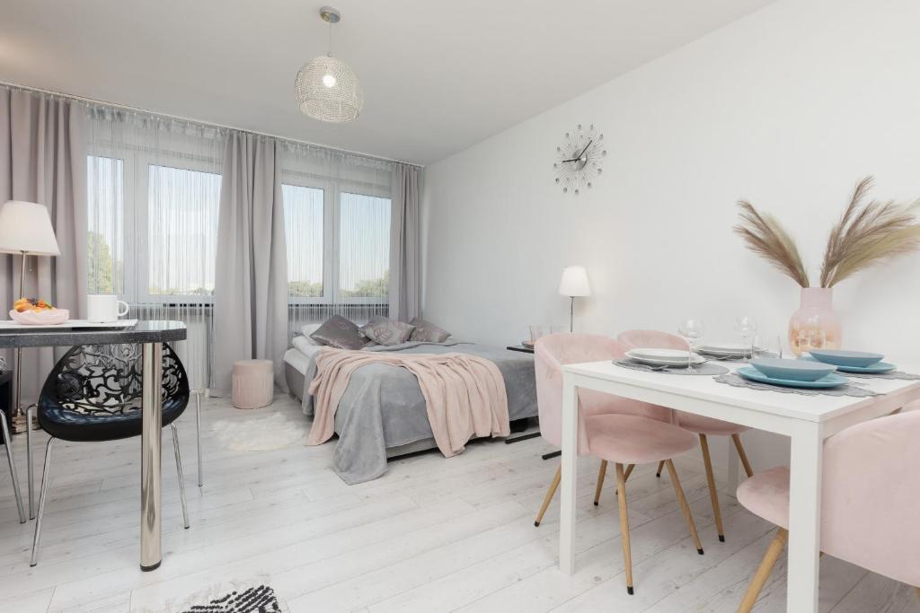 a white living room with a bed and a table at Bright & Cozy Studio near Metro Marymont by Renters in Warsaw