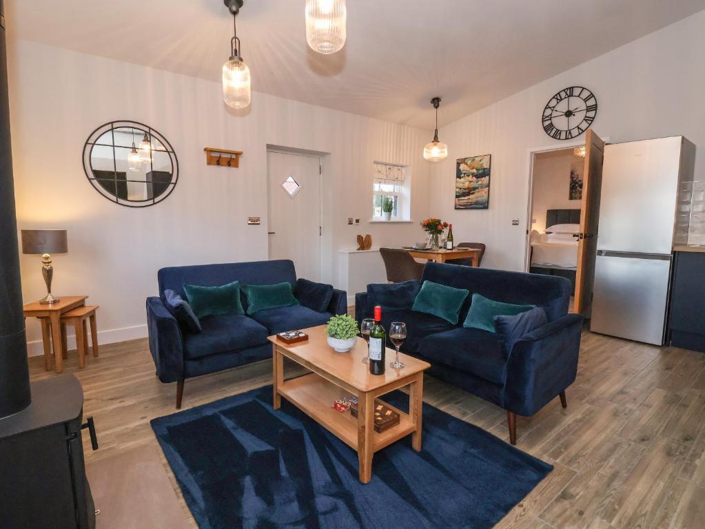a living room with two blue couches and a table at Robins Nest in York
