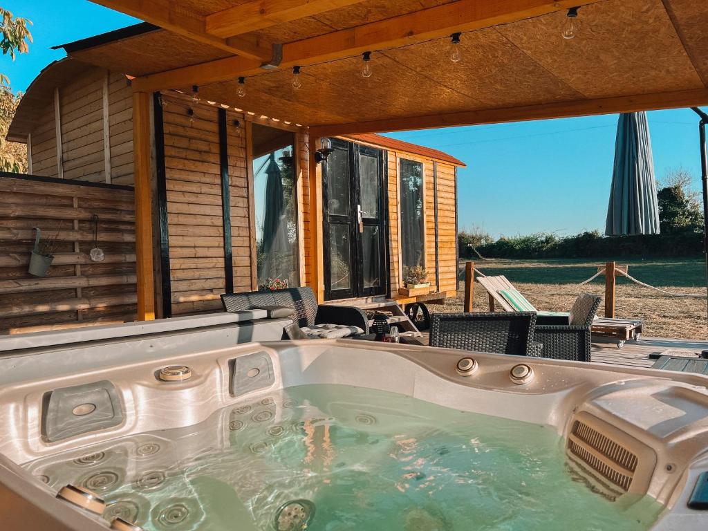 a hot tub in front of a house at Roulotte „douceur“ in Condom