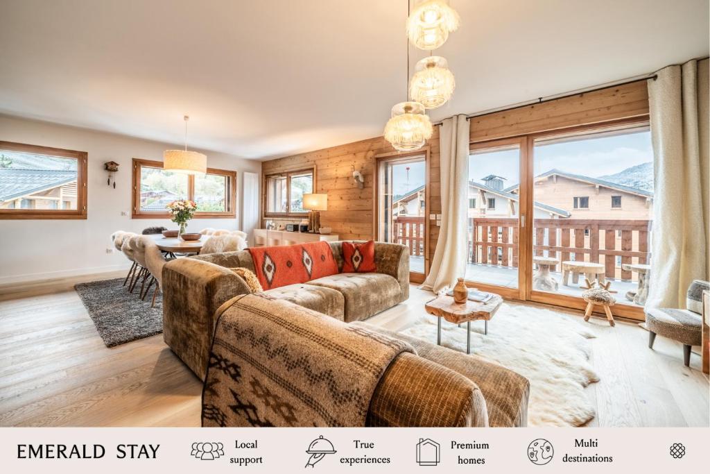 a living room with couches and a large window at Apartment Centaurea Megève - BY EMERALD STAY in Megève