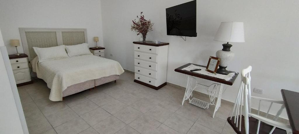 a bedroom with a bed and a dresser and a television at Heart Depto 2 Viedma Centro Confortable y Optima Ubicación in Viedma