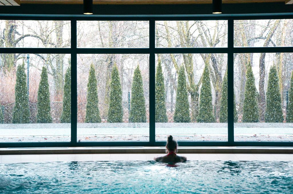 a person in a swimming pool looking out of a window at Apartamenty Ciechocinek SPA in Ciechocinek