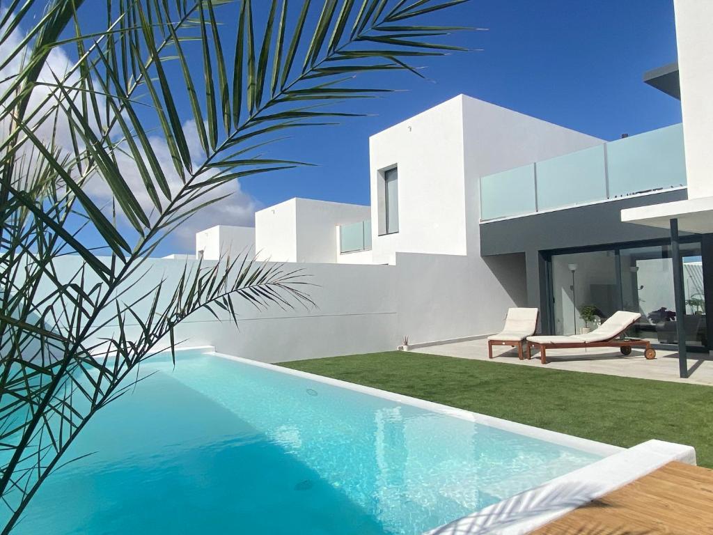 a swimming pool in front of a house at Villa Sol Fuerteventura in La Oliva