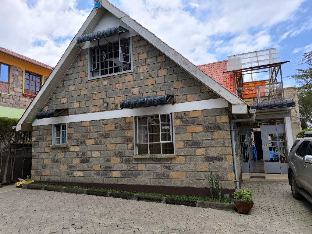 a house with a car parked in front of it at Weavers Haven in Naivasha