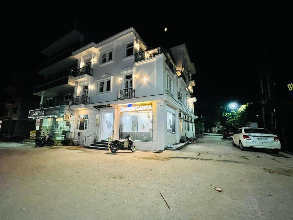 un edificio blanco con una motocicleta estacionada frente a él en Divine Ganga by MJ Hospitality en Haridwār