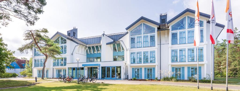 un gran edificio blanco con ventanas azules en BSW Hotel Ahlbeck en Ahlbeck