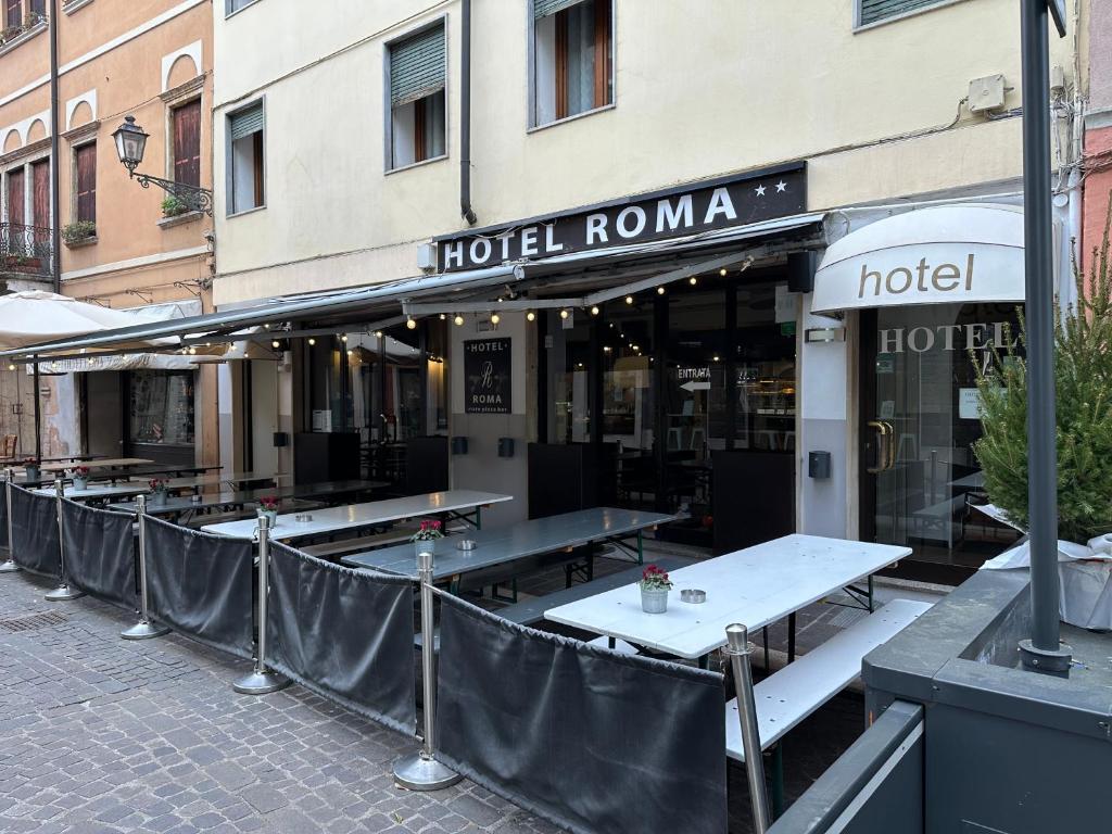 una fila di tavoli di fronte a un hotel di Albergo Roma a Valdagno