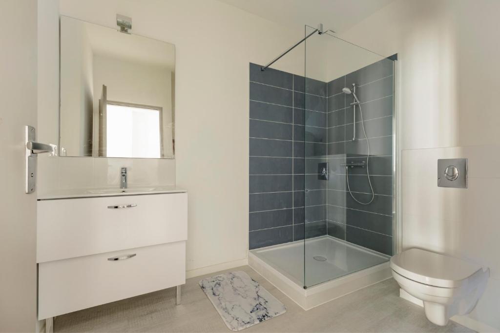a bathroom with a shower and a toilet and a sink at LE BLEU - Lumineux, 1 chambre, salle de bain moderne in Castelsarrasin