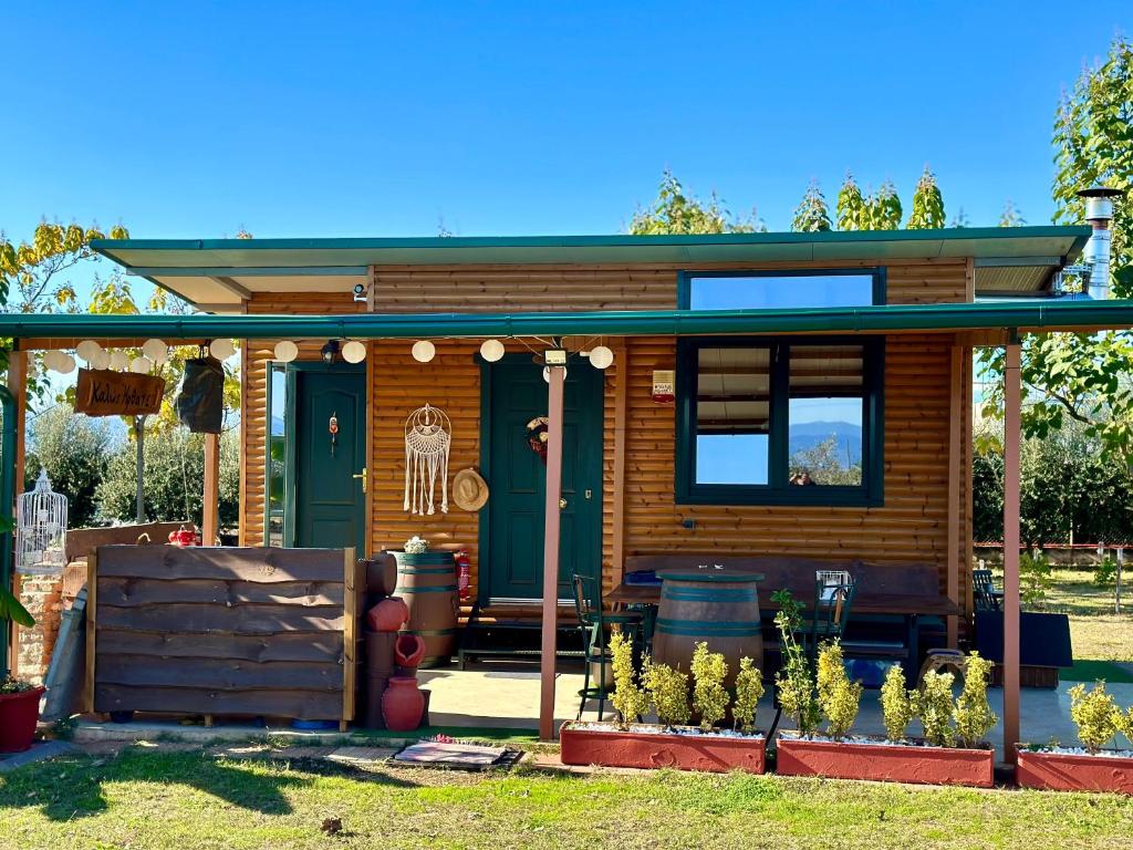 une petite maison en bois avec une porte verte dans l'établissement Avra Wooden House, à Dráma
