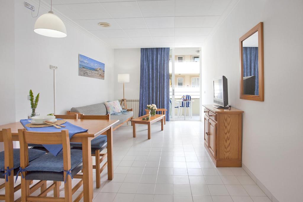 a living room with a dining table and a television at Apartamento Estándar 1 in Colonia Sant Jordi