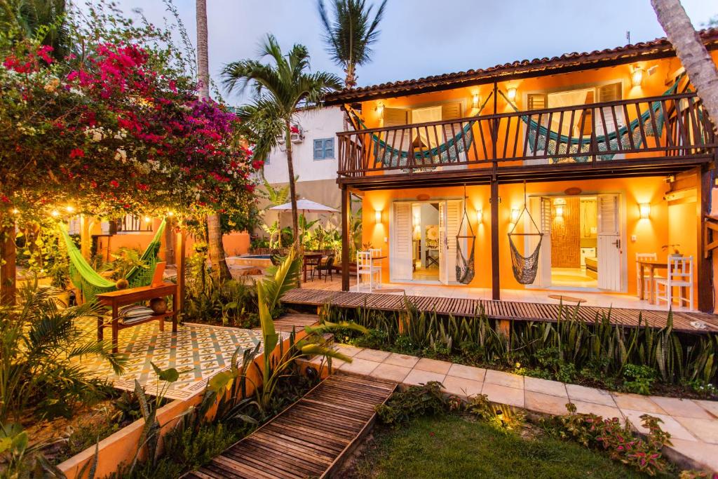 a house with a balcony and a garden at Vila Charme in Jericoacoara