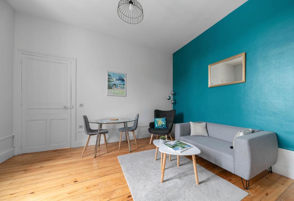 a living room with a couch and a table at Le Clem - Appartement centre ville - Idéal Cure et Parcs in Vichy