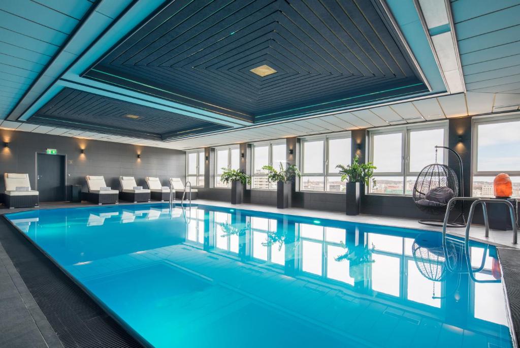 a large swimming pool in a building with a large ceiling at PLAZA Premium Darmstadt in Darmstadt