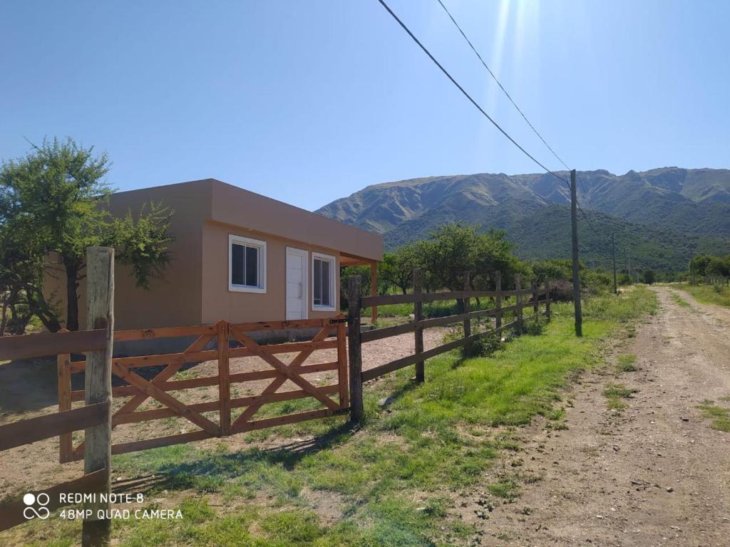 a house with a fence next to a dirt road at Casa de Montaña in Cortaderas
