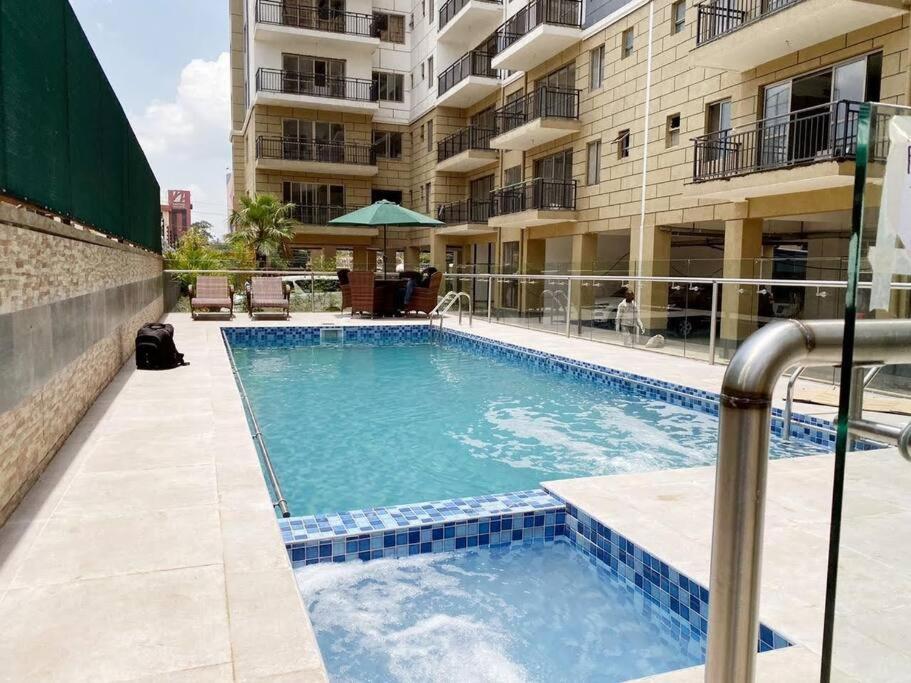 a swimming pool in front of a building at 2 Bedroom in Kilimani Ngong Rd in Nairobi