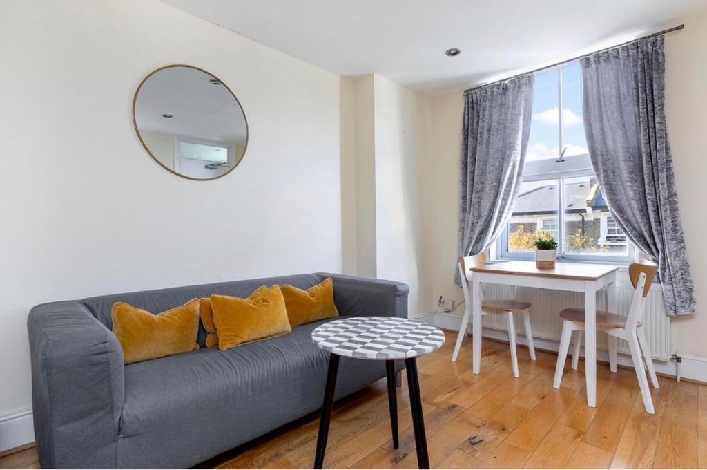 a living room with a gray couch and a table at Charming apartment, sleeps 4- 15 mins to Central in London
