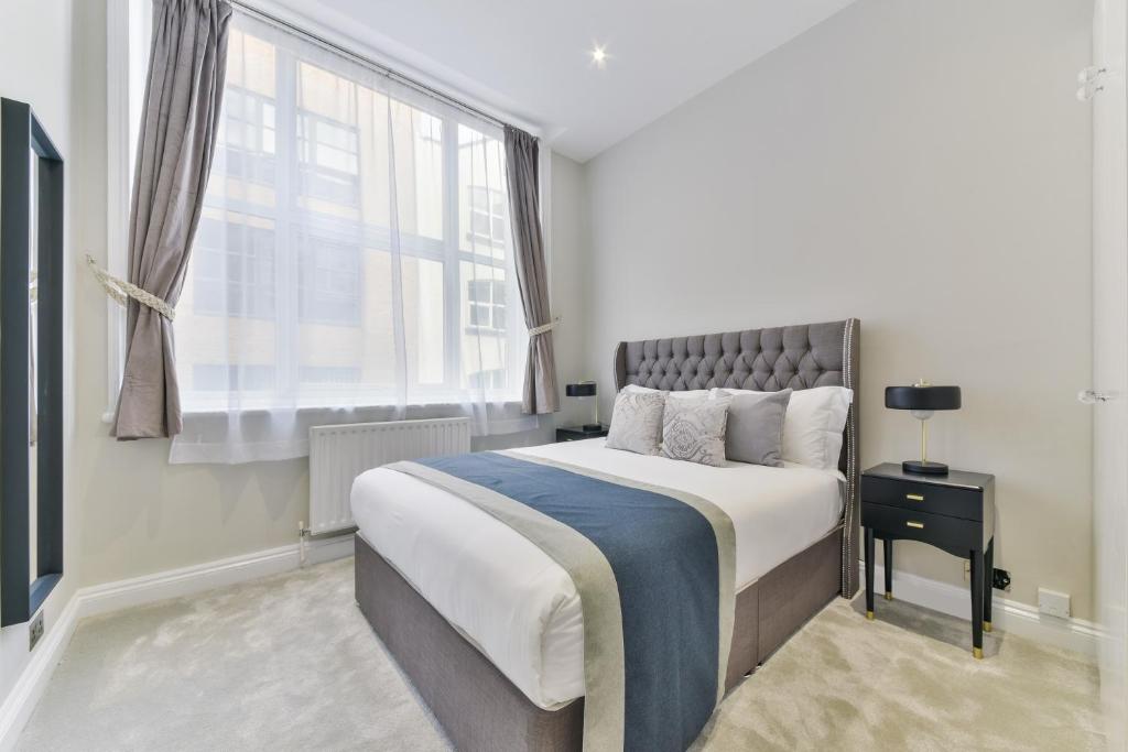 a bedroom with a large bed and a window at Avari Apartments - Hatton Collection in London
