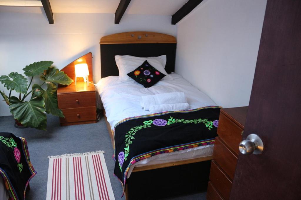 1 dormitorio con cama con almohada en Departamento súper comodo, en Cusco