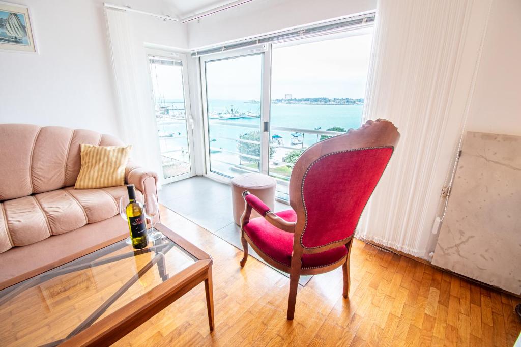 a living room with a red chair and a glass table at Apartment Umag Center Istria Croatia in Umag