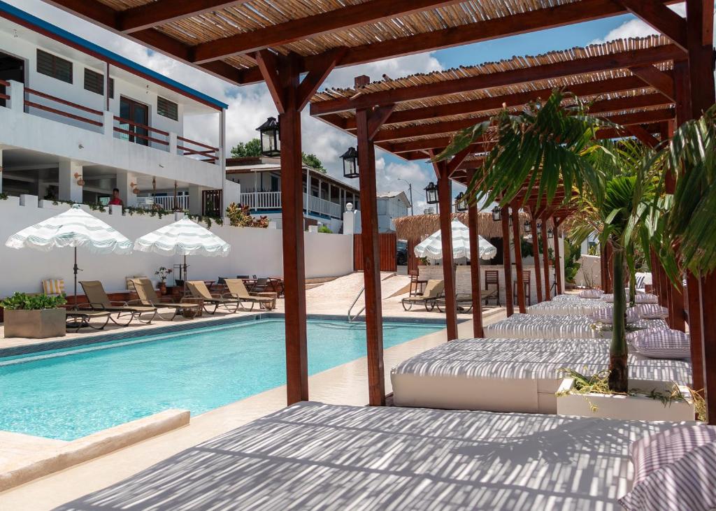 a swimming pool with chairs and umbrellas next to a resort at Parguera Plaza Hotel - Adults Only in La Parguera