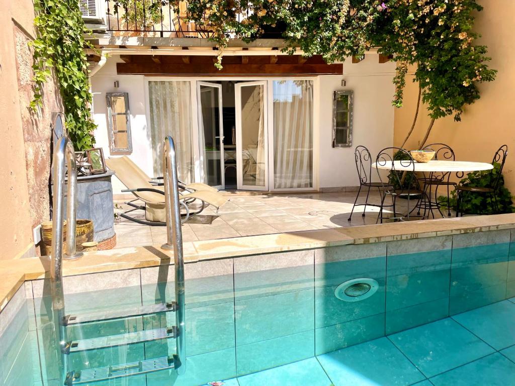 una piscina con mesa y sillas junto a una casa en Can Raixa, en Lloseta