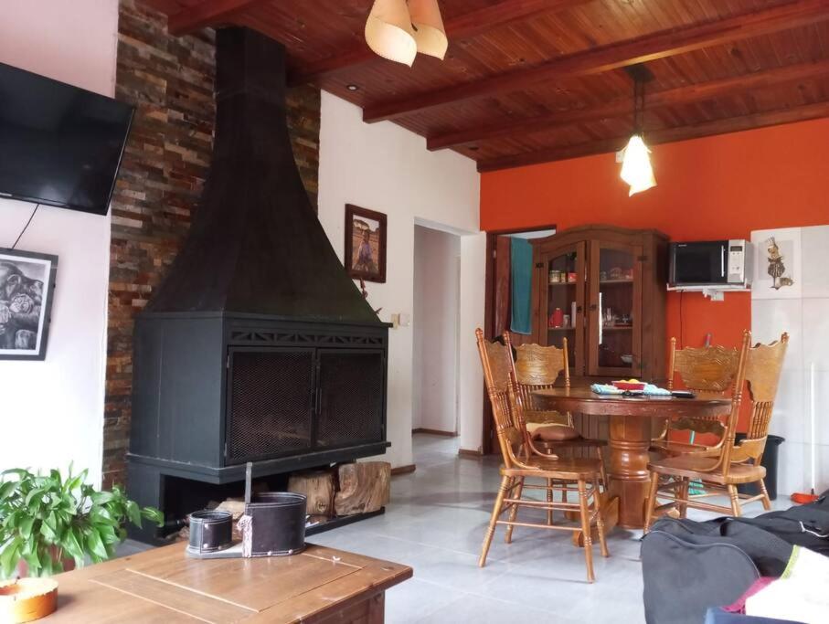 uma sala de estar com uma mesa e uma lareira em Lo de Mora em Costa Azul