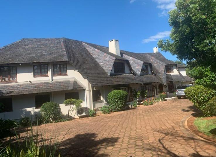 a large white house with a brick driveway at Forest Dream House in Kloof